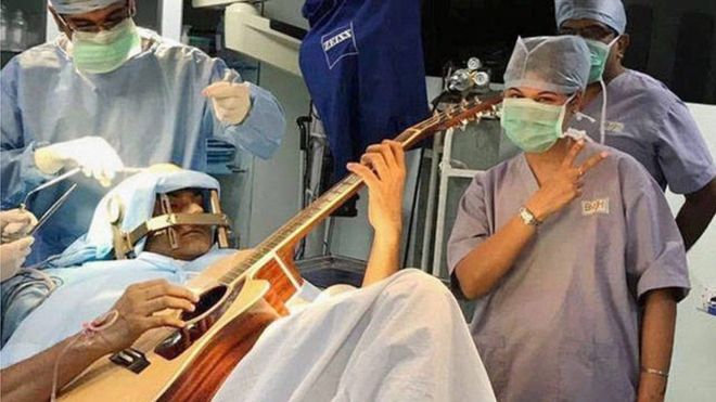 هندي يعزف الغيتار أثناء خضوعه لجراحة في المخ